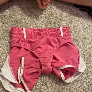 Pink and white athletic shorts with built in underwear.